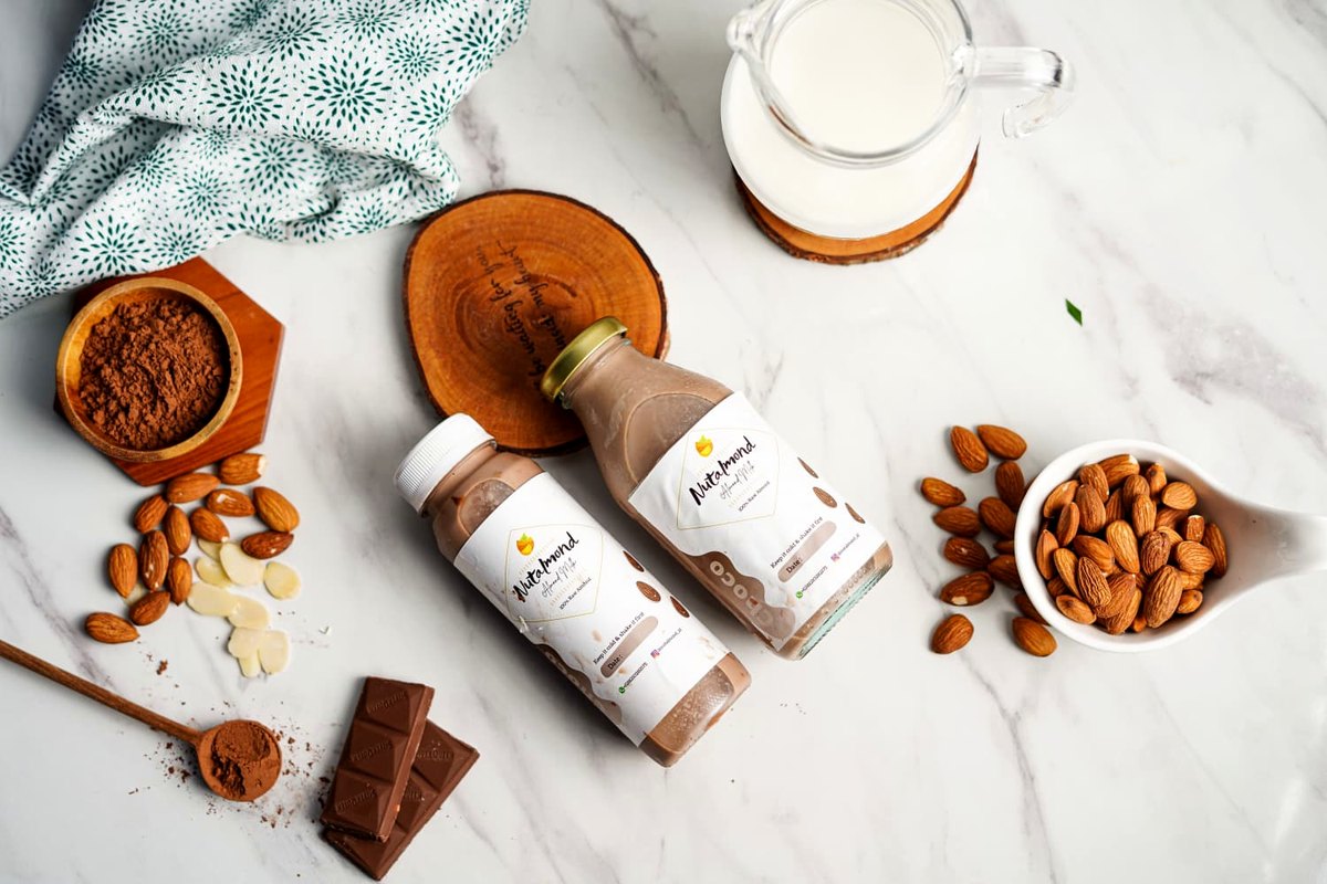 Nutalmond almond milk bottles with fresh almonds and cocoa
