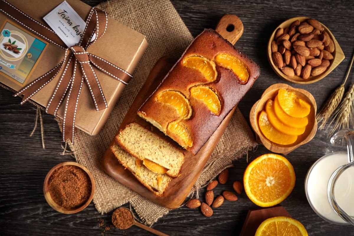 Sliced orange almond-flour loaf cake with fresh oranges and almonds